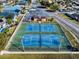 Aerial shot of blue and green tennis courts surrounded by a fence and landscaping, showcasing the community's amenities at 1102 Bocana Dr # 1102, Casselberry, FL 32707