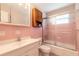 Bathroom with pink tile, white vanity, and shower with sliding glass doors at 1117 Berkshire Rd, Daytona Beach, FL 32117
