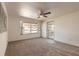Sunlit living room with neutral carpeting, ceiling fan, and view of the home's front exterior at 1117 Berkshire Rd, Daytona Beach, FL 32117
