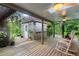 Enjoy the backyard's covered deck with rocking chairs and a charming shed surrounded by lush foliage at 120 Beach St, Ponce Inlet, FL 32127