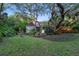 Expansive backyard with lush lawn, mature trees, and a charming shed near a cozy seating area at 120 Beach St, Ponce Inlet, FL 32127