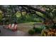 Spacious backyard with trees, manicured landscaping, and Adirondack chairs at 120 Beach St, Ponce Inlet, FL 32127
