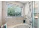 Modern bathroom featuring a garden tub and natural lighting from a window at 120 Beach St, Ponce Inlet, FL 32127