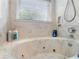Bathroom featuring a jetted tub, shower and natural lighting from a window at 120 Beach St, Ponce Inlet, FL 32127