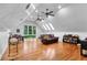 Large bonus room with hardwood floors, a vaulted ceiling, and a leather couch at 120 Beach St, Ponce Inlet, FL 32127