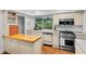 Bright kitchen with hardwood floors, island, stainless steel appliances, and natural light at 120 Beach St, Ponce Inlet, FL 32127