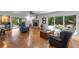 Spacious living room featuring hardwood floors, a brick fireplace, and access to the outdoor pool area at 120 Beach St, Ponce Inlet, FL 32127