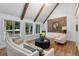 Inviting living room featuring vaulted ceilings, wooden beams, large picture windows, and hardwood flooring at 120 Beach St, Ponce Inlet, FL 32127