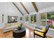 Living room with wooden beams, a view of the landscaped yard, and large windows at 120 Beach St, Ponce Inlet, FL 32127