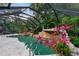 Screened in pool with rock waterfall and tropical landscaping detail at 120 Beach St, Ponce Inlet, FL 32127