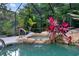 Secluded pool area with lush tropical plants and rock features create a peaceful outdoor escape at 120 Beach St, Ponce Inlet, FL 32127