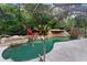 Screened pool with rock waterfall feature and jacuzzi, with tropical plants surrounding the concrete pool deck at 120 Beach St, Ponce Inlet, FL 32127