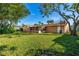 Large backyard featuring a screened-in lanai, mature trees, and a well-maintained lawn at 1216 Sunland Rd, Daytona Beach, FL 32114
