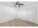 A bright bedroom features light grey floors, white walls, a black ceiling fan, and closet with doors at 1216 Sunland Rd, Daytona Beach, FL 32114