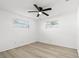 A bright bedroom features light grey floors, white walls, a black ceiling fan, and two bright windows at 1216 Sunland Rd, Daytona Beach, FL 32114