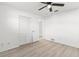 A bright bedroom features light grey floors, white walls, a black ceiling fan, and closet with doors at 1216 Sunland Rd, Daytona Beach, FL 32114