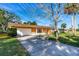 View of the exterior showing the driveway leading to the two car garage, landscaping, and freshly cut lawn at 1216 Sunland Rd, Daytona Beach, FL 32114