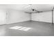 A spacious garage is shown with white walls, gray epoxy floors and a large white garage door at 1216 Sunland Rd, Daytona Beach, FL 32114