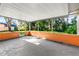 An enclosed patio featuring orange walls and a gray floor is surrounded by tropical trees at 1216 Sunland Rd, Daytona Beach, FL 32114