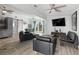 Living room boasting an open floorplan, a large-screen television, ceiling fans and wood-look tile flooring at 1268 Bel Aire Dr, Daytona Beach, FL 32118