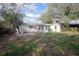 Backyard with a view of the back of the house with mature landscaping and a small porch at 137 Lucerne Dr, Debary, FL 32713