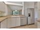 Galley kitchen featuring stainless steel appliances and tiled floors with a view to the living room at 1429 Carlow Cir, Ormond Beach, FL 32174