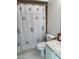 Bathroom featuring tiled floors, patterned shower curtain, and white toilet and sink at 168 Olive Tree Cir # 168, Altamonte Springs, FL 32714