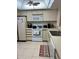Compact kitchen showing the stove, microwave, and ample cabinet space with neutral tones and tile flooring at 168 Olive Tree Cir # 168, Altamonte Springs, FL 32714