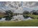 Picturesque community pond reflecting the cloudy sky and surrounding trees at 179 Moonstone Ct, Port Orange, FL 32129