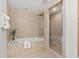 Bathroom featuring a soaking tub, glass enclosed shower, and neutral tile throughout at 1900 N Atlantic Ave # 901, Daytona Beach, FL 32118