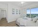 Bright bedroom featuring balcony access with city views, hardwood flooring, and ceiling fan at 1900 N Atlantic Ave # 901, Daytona Beach, FL 32118