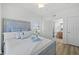Comfortable bedroom with hardwood floors, a ceiling fan, an open bathroom and bright natural light at 1900 N Atlantic Ave # 901, Daytona Beach, FL 32118