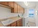 Practical laundry room featuring washer, dryer, storage cabinets, sink, and an ocean view at 1900 N Atlantic Ave # 901, Daytona Beach, FL 32118