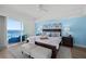 Bright main bedroom with ocean view balcony access, comfortable furnishings, and a serene blue accent wall at 1900 N Atlantic Ave # 901, Daytona Beach, FL 32118