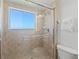 Clean shower with a tile surround, a sliding glass door, a window, and a shower head at 1900 N Atlantic Ave # 901, Daytona Beach, FL 32118