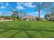 This expansive backyard features lush green grass and mature trees and landscaping at 1924 Seclusion Dr, Port Orange, FL 32128