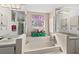 This well-lit bathroom has a stylish soaking tub, decorative accents, and a stained glass window at 1924 Seclusion Dr, Port Orange, FL 32128