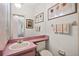 Pink bathroom featuring a single sink vanity, artwork, and decorative towels hanging on the wall at 1924 Seclusion Dr, Port Orange, FL 32128