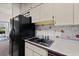 Kitchen boasts white cabinets and a black refrigerator, complemented by charming floral wallpaper at 1924 Seclusion Dr, Port Orange, FL 32128