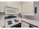 Bright kitchen featuring white cabinetry, appliances, counters and a light-colored floor at 1924 Seclusion Dr, Port Orange, FL 32128