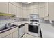 Well-lit kitchen featuring white cabinets, a microwave, and a range with plenty of counter space at 1924 Seclusion Dr, Port Orange, FL 32128