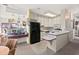 Efficient kitchen design with white cabinetry and black appliances, featuring an adjacent dining area at 1924 Seclusion Dr, Port Orange, FL 32128