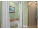 This bathroom features a shower, bathtub, tiled floor, and painted green walls at 2 Oceans West Blvd # 1905, Daytona Beach Shores, FL 32118