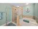 Shower and tub in bathroom with tiled enclosure, teal accent wall and decorative accents at 2 Oceans West Blvd # 1905, Daytona Beach Shores, FL 32118