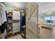 Walk-in closet and bedroom with weathered wood barn door, closet with shelving, drawers and hanging space for clothing and shoes at 2 Oceans West Blvd # 1905, Daytona Beach Shores, FL 32118