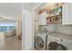 Laundry room with side-by-side washer and dryer with storage shelves, and is adjacent to main living space at 2 Oceans West Blvd # 1905, Daytona Beach Shores, FL 32118