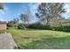 Well-maintained backyard, featuring a lush lawn, mature trees, and a privacy hedge at 205 Victoria Trails Blvd, Deland, FL 32724