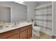 Bathroom with a light wood vanity, quartz countertops, and a shower with a horizontally striped shower curtain at 205 Victoria Trails Blvd, Deland, FL 32724
