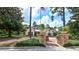 Community clubhouse featuring brick-paved entrance and beautiful stone pillars showcasing lush landscape and an American flag at 205 Victoria Trails Blvd, Deland, FL 32724