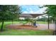 Community playground shaded by a large canopy featuring a slide, swings, and other playground equipment for residents at 205 Victoria Trails Blvd, Deland, FL 32724